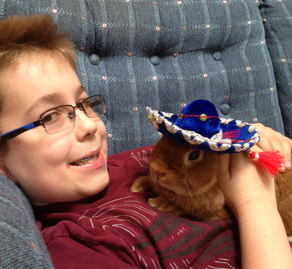 Rabbit relief: Matthew Giesse, who has both Crohn’s disease and autism, plays with one of his pet rabbits during a relatively pain-free moment. Courtesy of the Giesse family