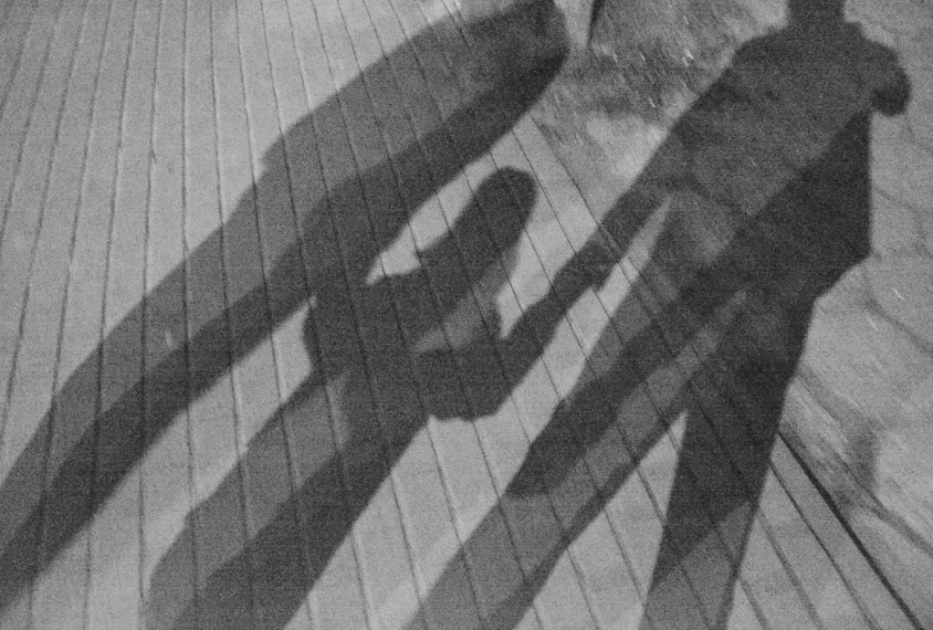 diagonal shadow of a family--parents and a girl
