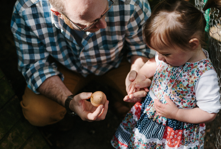 Gillian excitedly shows his daughter, Izzie, an egg.