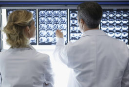 Two doctors reviewing brain scans.