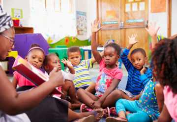 Children in pre-school sitting around a learning circle.