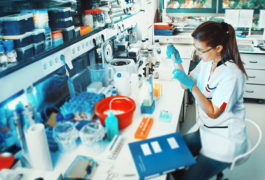 female lab scientist experimenting in cluttered space