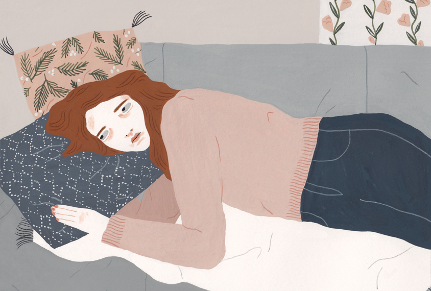 Illustration: a woman lies on a couch, on her side, looking sad.