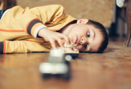 boy lying down on the floor touching a metal object