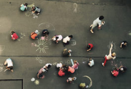 birdseye view of children drawing with chalk on the sidewalk